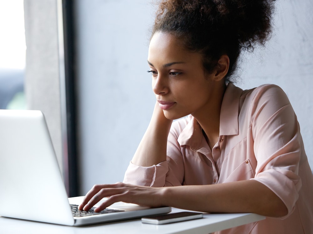 Woman looking at a laptop in deep thought