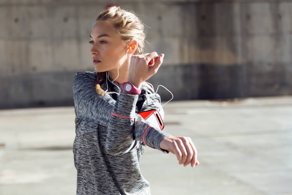 Stylish woman stretching in workout clothing