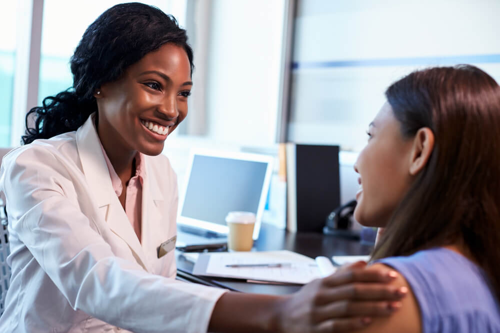 Smiling doctor talking to happy patient