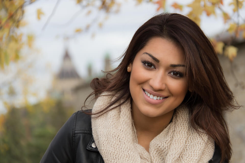 Young, stylish woman smiling outside